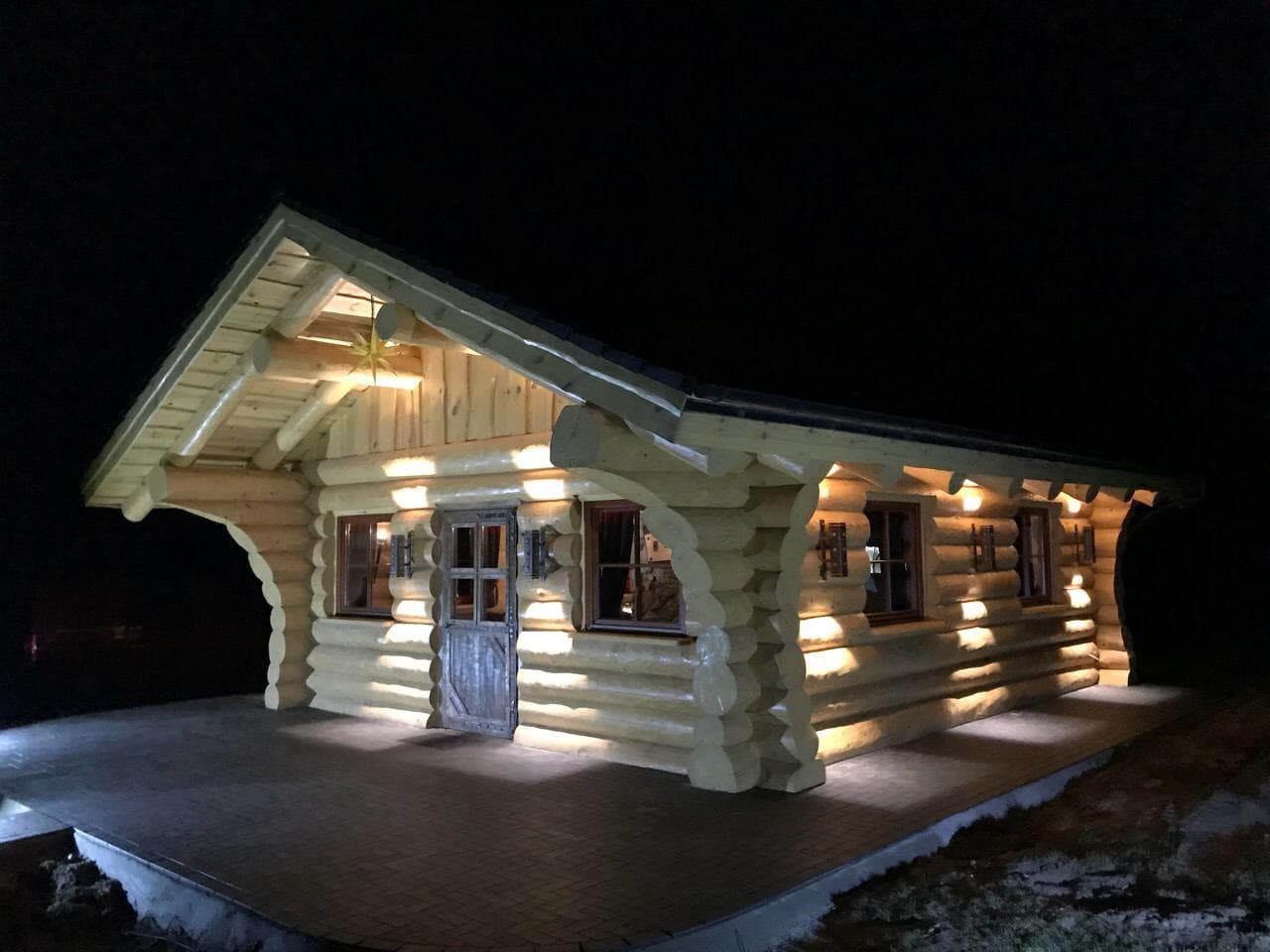 Зруб уночі з архітектурним підсвічуванням